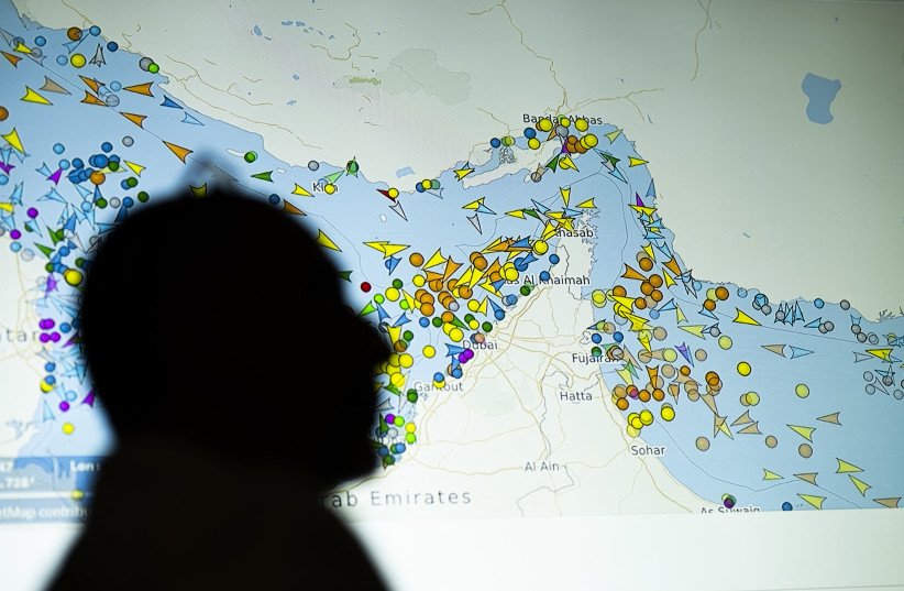 A photo illustration taken in Nicosia on May 4, 2026, shows a person in front of a large screen displaying vessel movements in the Strait of Hormuz on a ship-tracking website.