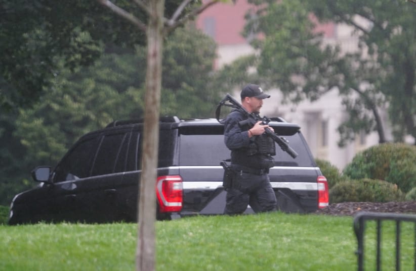 A US Secret Service agent walks holding his weapon after alleged gunshots were heard nearby, at the White House in Washington, DC, US, May 23, 2026.
