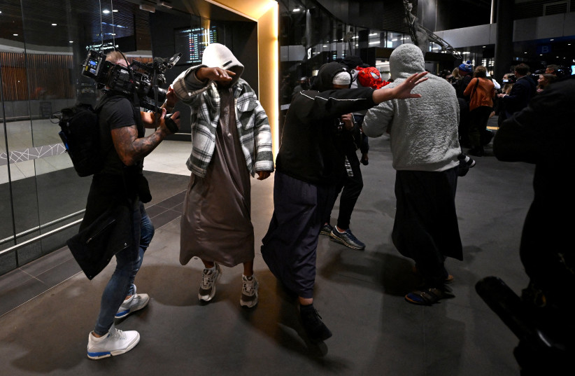 A group of supporters surround an Islamic State-linked family, as they arrive at Melbourne international airport, in Melbourne, Australia, May 7, 2026. 13 women and children are set to return to Australia after years spent in a Syrian refugee camp following the fall of Islamic State.