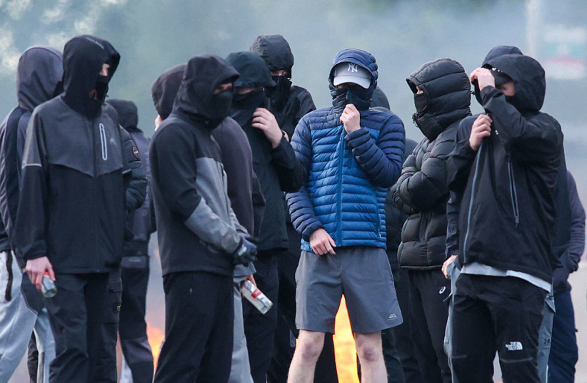 MASKED YOUTHS block a road with burning debris in north Belfast, Northern Ireland, in the evening of June 9, 2026.
