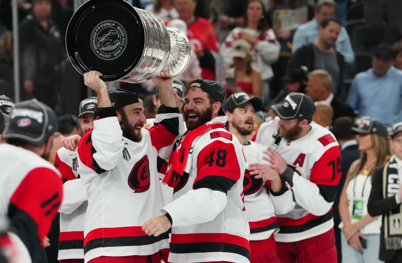 Carolina Hurricanes left wing Jordan Martinook (48) hands the the Stanley Cup to defenseman Shayne Gostisbehere (4) after defeating the Vegas Golden Knights in game six of the 2026 Stanley Cup Final at T-Mobile Arena, June 14, 2026.