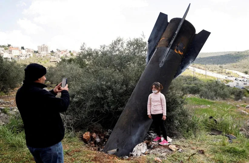 Una niña posa para una foto junto a los restos de un misil clavado en el suelo que se encontró en la aldea de Kifl Haris, cerca de Nablus, en Cisjordania, el 24 de marzo de 2026.