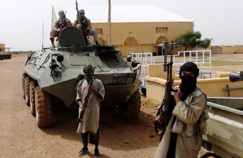 Fighters from the Al Qaeda-linked Islamist group MUJWA, who are travelling with a convoy including Burkina Faso foreign minister Djibril Bassole, stand guard in Gao, northern Mali, August 7, 2012.