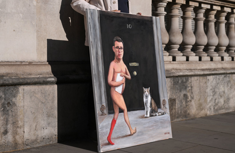 Political satire artist Kaya Mar stands with a painting depicting Labour leader Andy Burnham and Larry the cat outside Downing Street on the day of the transfer of power from outgoing Prime Minister Keir Starmer to Labour leader Andy Burnham, in London, Britain, July 20, 2026.