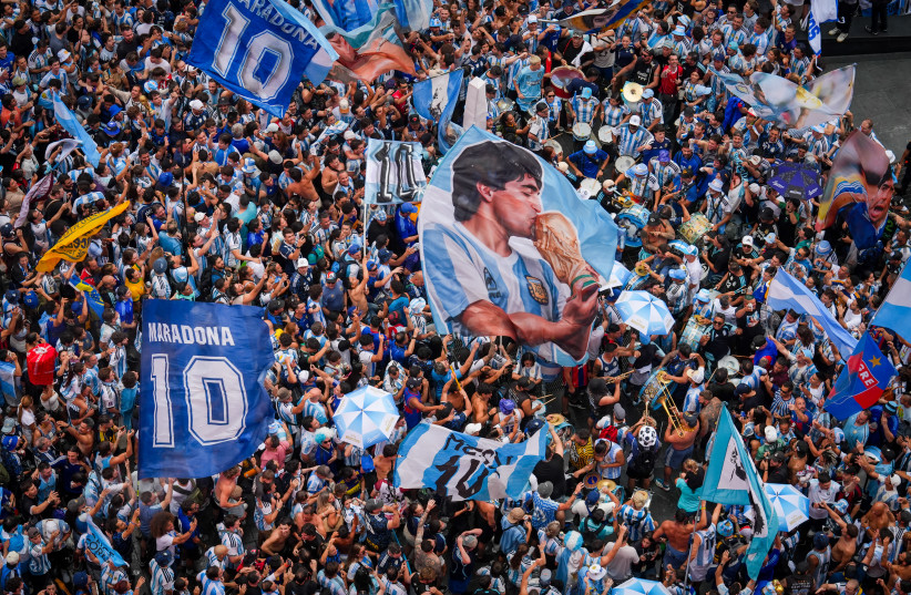 This aerial view shows Argentina's fans waving a flag with an image of late football legend Diego Maradona while cheering for their team at Times Square in New York City, on July 18, 2026.