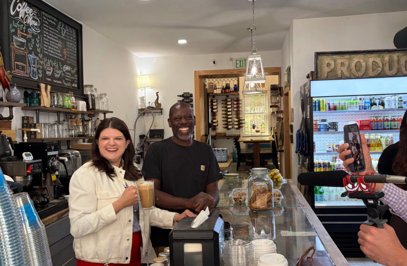 Democratic US Rep. and Michigan US Senate candidate Haley Stevens (l) tries a cappuccino she made during a campaign stop at a cafe in Detroit, Michigan, July 27, 2026.