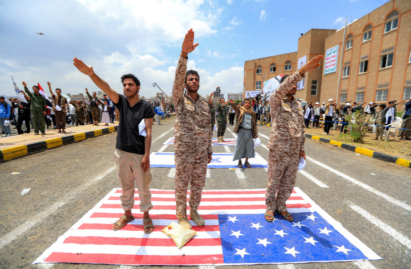 Men gesture as they express their affiliation and support for the Houthi movement while standing over a depiction of the US flag during a demonstration by university students amid escalating tensions with Saudi Arabia, at the Sanaa University campus in Yemen's Houthi-held capital Sanaa on July 22.