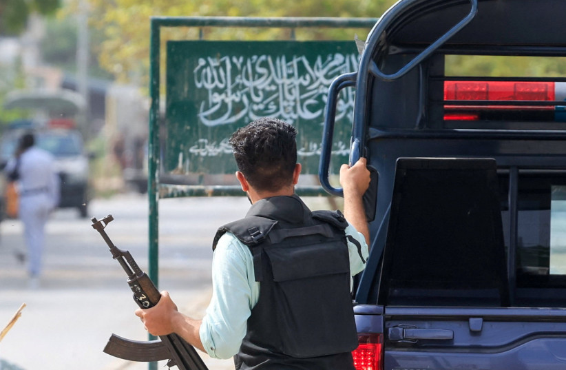 A security officer in plain clothes walks with his gun outside the office of the Rangers, a paramilitary force, following an explosion and gunfire reported on Saturday night in Karachi, Pakistan, June 28, 2026.