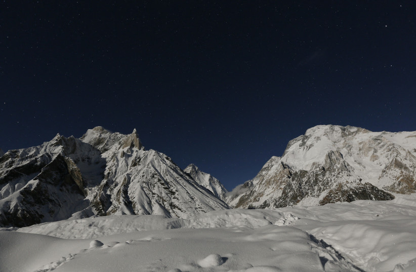 The world's second largest mountain, the 8,611 meter high K2 (seen in the distance), and the 8,051 meter high Broad Peak (R), are illuminated by the moon at Concordia, the confluence of the Baltoro and Godwin-Austen glaciers, in the Karakoram mountain range in Pakistan September 7, 2014.