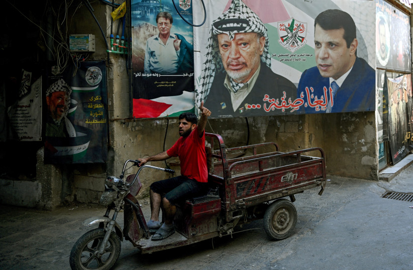 A man drives a tuk-tuk past portraits of late Palestinian President Yasser Arafat (C) and former Fatah security chief in Gaza Mohammed Dahlan (R) in Beirut's Burj al-Barajneh camp for Palestinian refugees on May 14, 2024; illustrative.