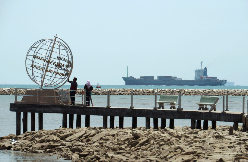 A container ship enters the Singapore Strait for the Strait of Malacca, as tourists stand at mainland Asia's southern most point in Johor, Malaysia November 12, 2016. Picture taken November 12, 2016.