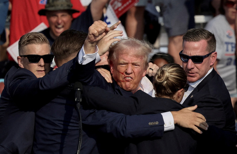 Republican presidential candidate and former U.S. President Donald Trump is assisted by the Secret Service after gunfire rang out during a campaign rally at the Butler Farm Show in Butler, Pennsylvania, US, July 13, 2024.