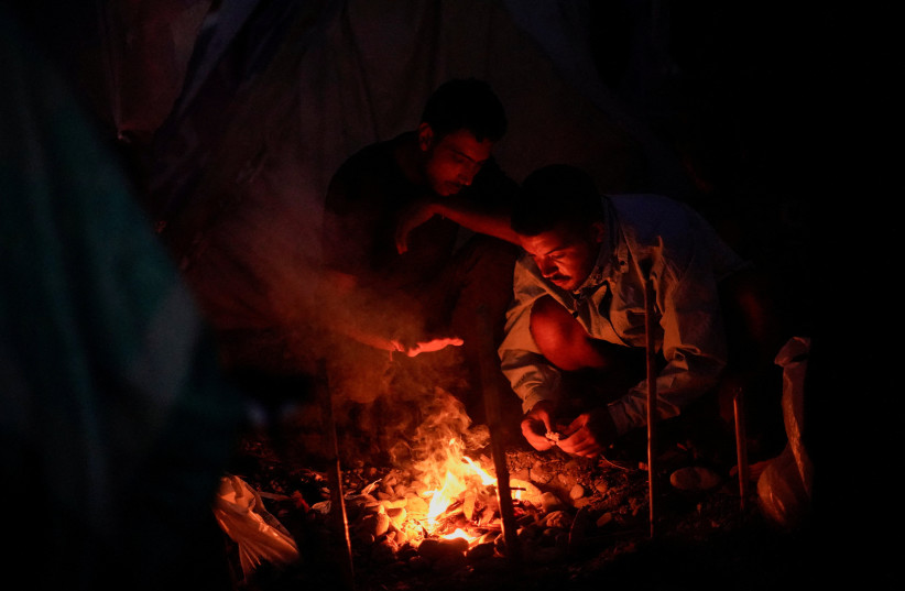 People set a bonfire to cook dinner at the Trampolin beach settlement following the mass crossing of migrants from Morocco, in Ceuta, Spain, September 16, 2026.