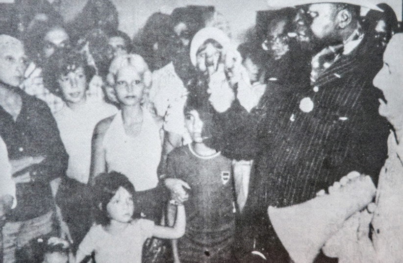 MICHEL COJOT (right) interprets president Idi Amin’s words for the hostages (including his son) during the Air France hijacking.