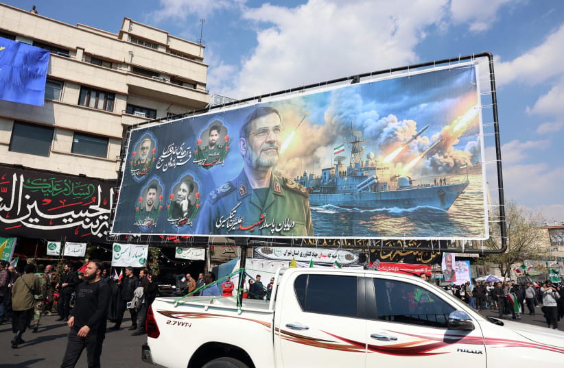 A banner showing the face of Alireza Tangsiri, commander of the Iranian Revolutionary Guards' navy alongside others killed in US-Israeli strikes on Iran, is displayed during their funeral at Enghelab Square in Tehran on April 1, 2026.