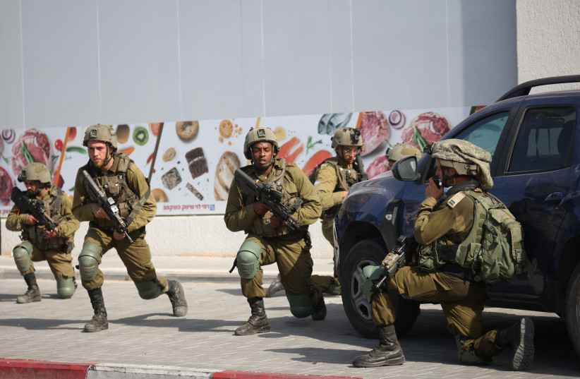 Israeli soldiers deploy in an area where civilians were killed in the southern city of Sderot on October 7, 2023.
