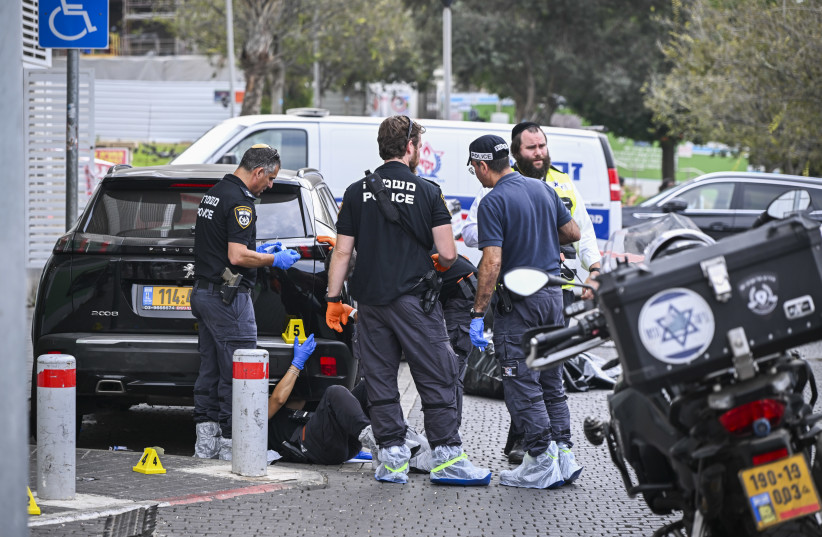 Israeli police and forensic investigators at the scene of a fatal shooting outside a bank on Moshe Dayan Street in Tel Aviv, where two men in their 50s were found shot dead. Police are investigating a suspected murder-suicide, October 26, 2026.