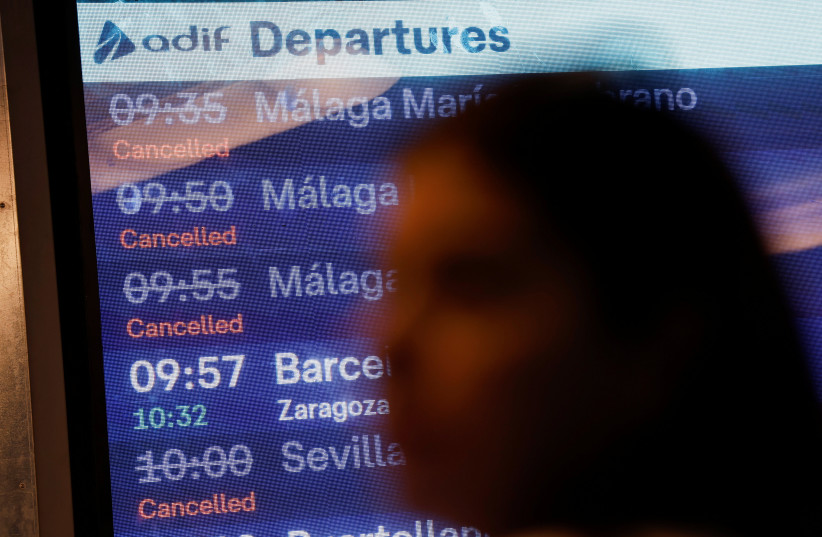 A woman walks past an information screen displaying cancelled train services following the collision of two high-speed trains between the towns of Mora and Orgaz, at the Atocha train station in Madrid, Spain, October 28, 2026.