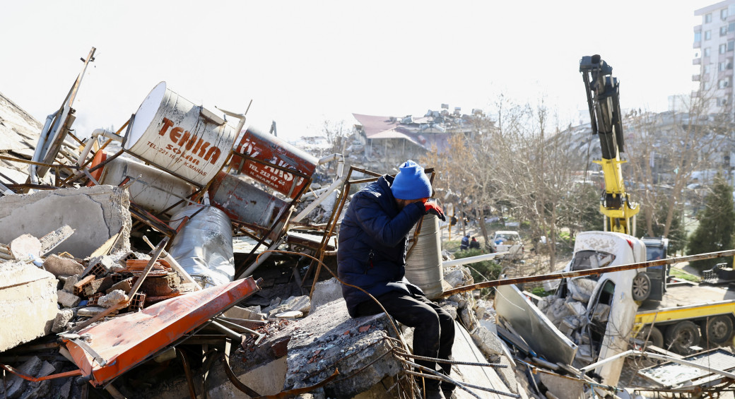  A person reacts while sitting on the rubble of a collapsed building, in the aftermath of an earthquake, in Kahramanmaras, Turkey, February 9, 2023 (photo credit: REUTERS/Ronen Zvulun)
