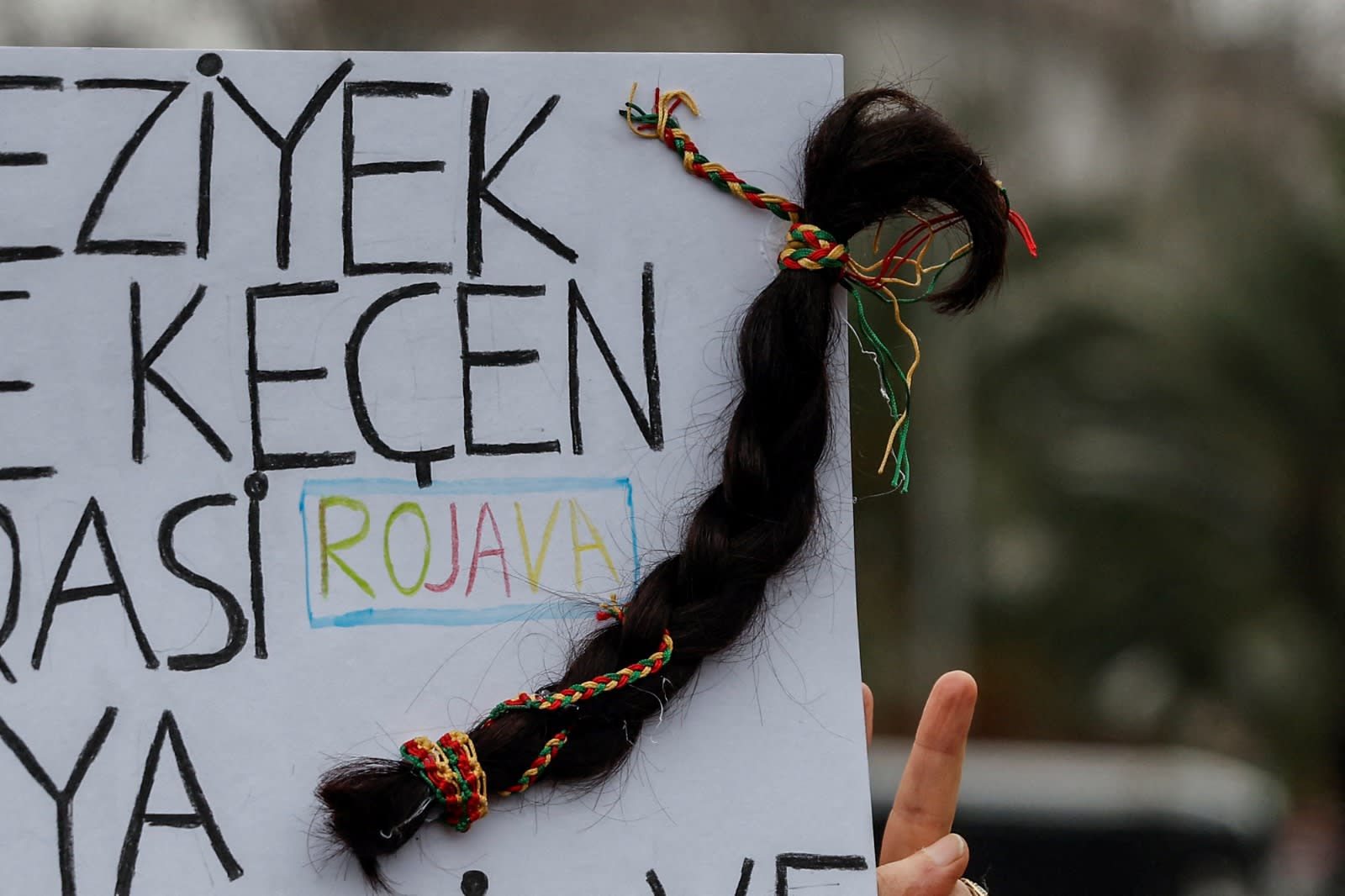 DEMONSTRATORS HOLD a placard featuring a braided hair as a symbolic act of resistance and solidarity with Kurdish women in Syria, during a protest supporting Syrian Kurds after recent clashes between the Syrian army and Kurdish forces, in Istanbul, Turkey, January 24, 2026. (photo credit: REUTERS/Kemal Aslan TPX IMAGES OF THE DAY)