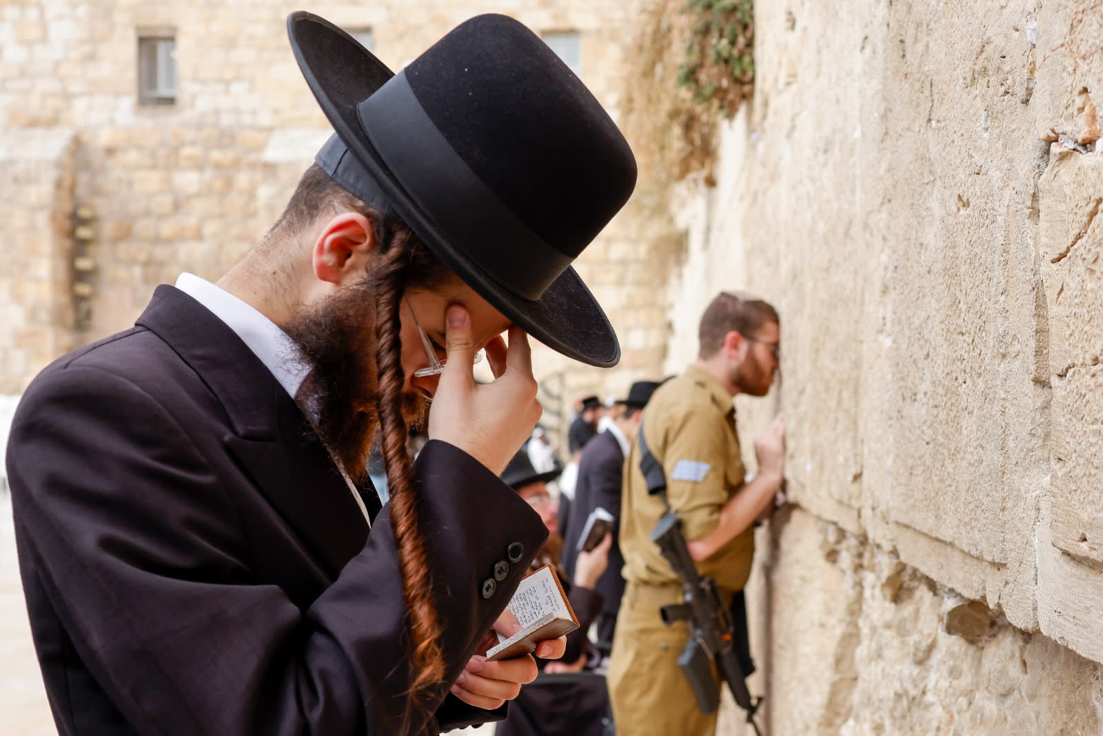  A haredi man and an IDF soldier pray at the Western Wall in Jerusalem, November 14, 2024 (photo credit: MARC ISRAEL SELLEM)