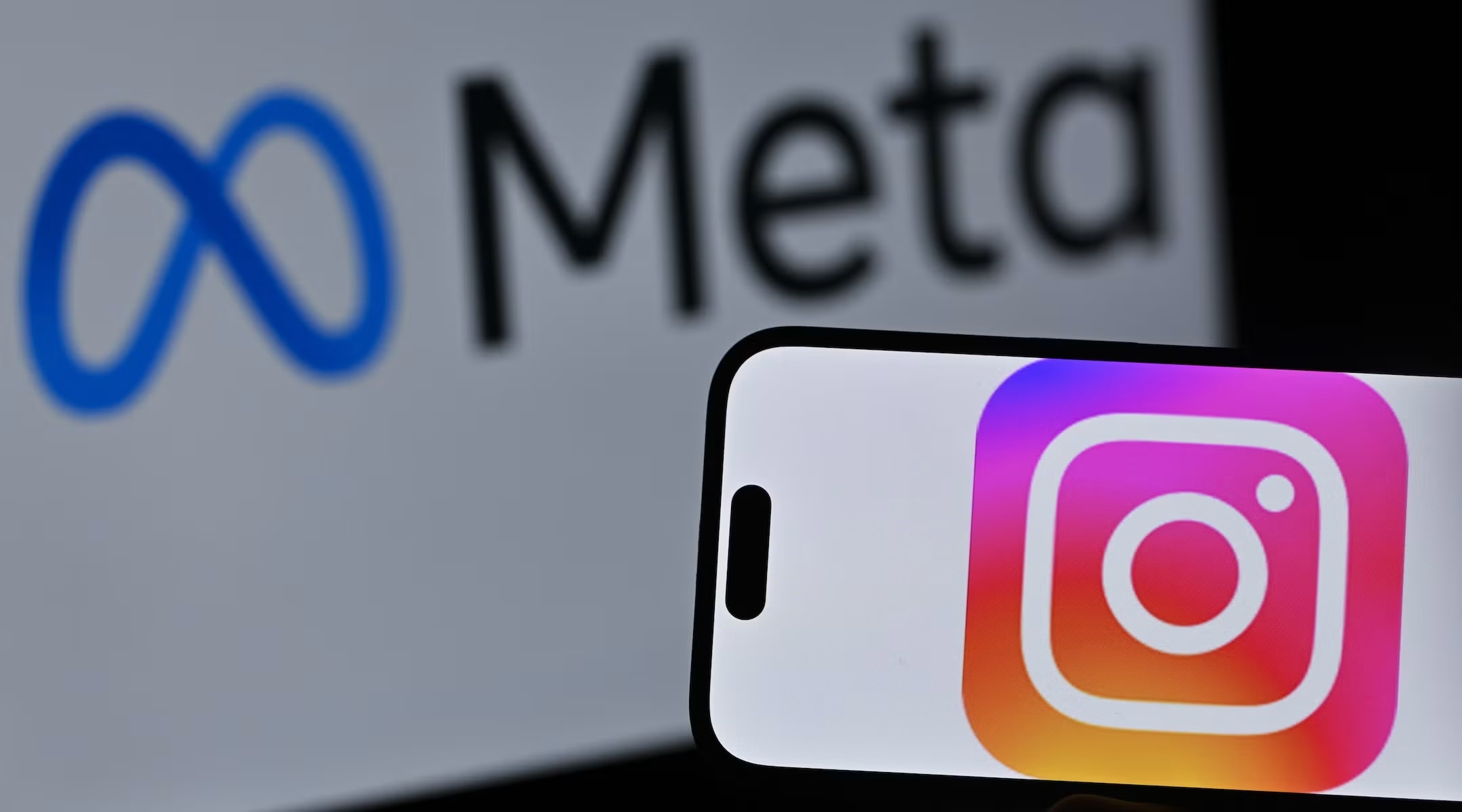 The Instagram logo is displayed on a mobile phone screen in front of a computer screen displaying Meta logo on April 10, 2026. (photo credit: Ismail Kaplan/Anadolu via Getty Images)