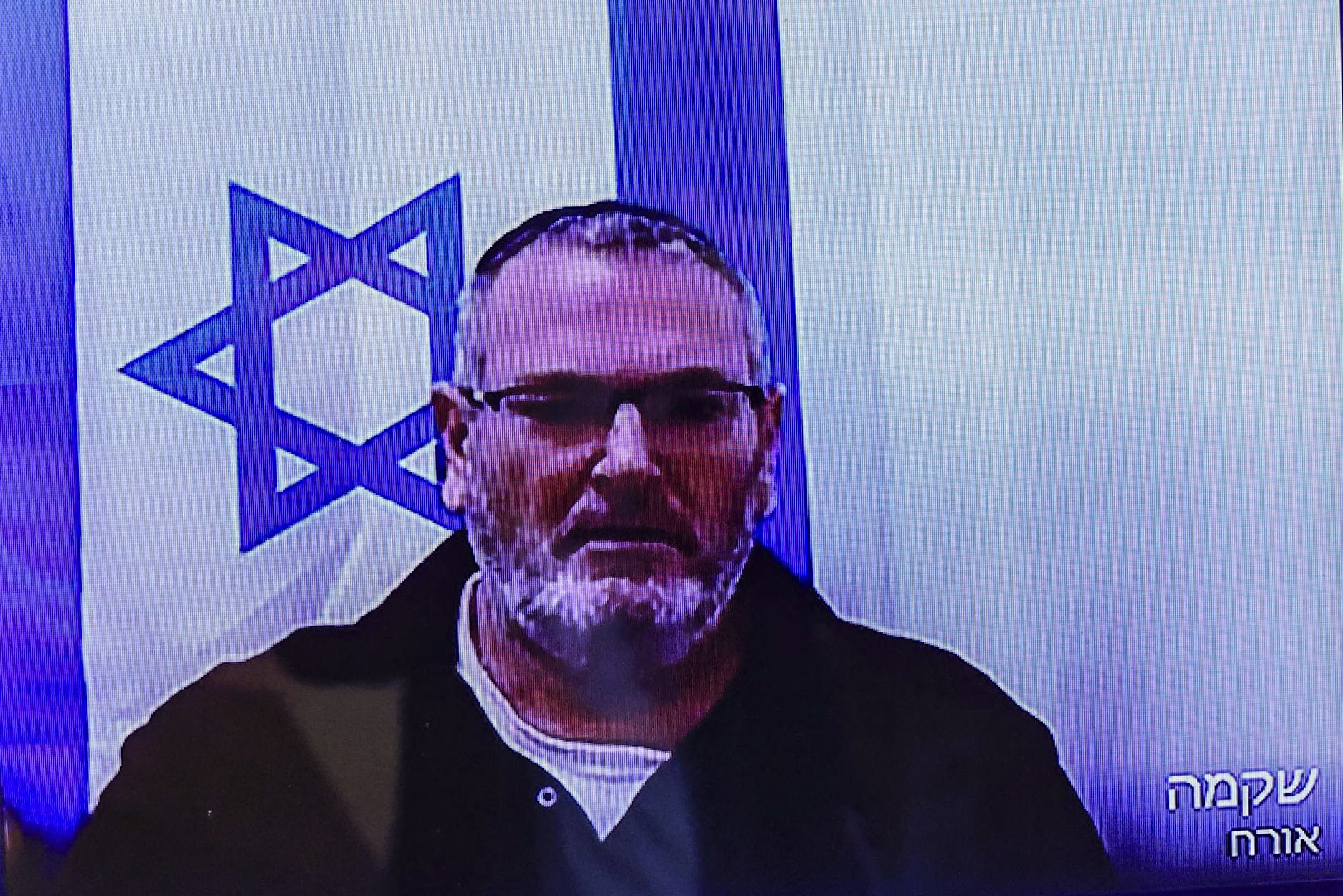 Bezalel Zini, accused of smuggling cigarettes into the Gaza Strip, is seen on a screen at the Beersheba District Court, February 5, 2026 (photo credit: Tsafrir Abayov/Flash90)