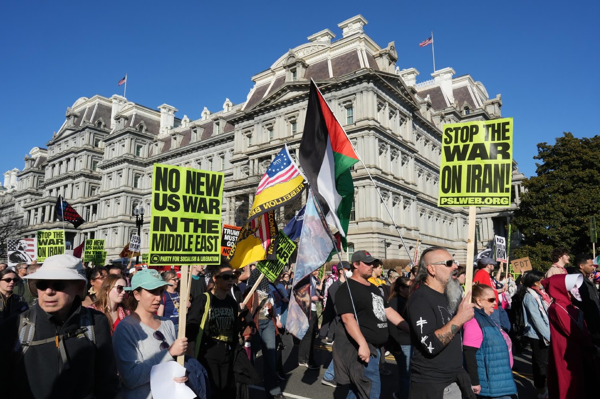 People wave Iranian flags and signs condemning the war on Iran as they march past the Eisenhower Executive Building during a protest in Washington, DC, on February 28, 2026.  (photo credit: Ken Cedeno / AFP via Getty Images)
