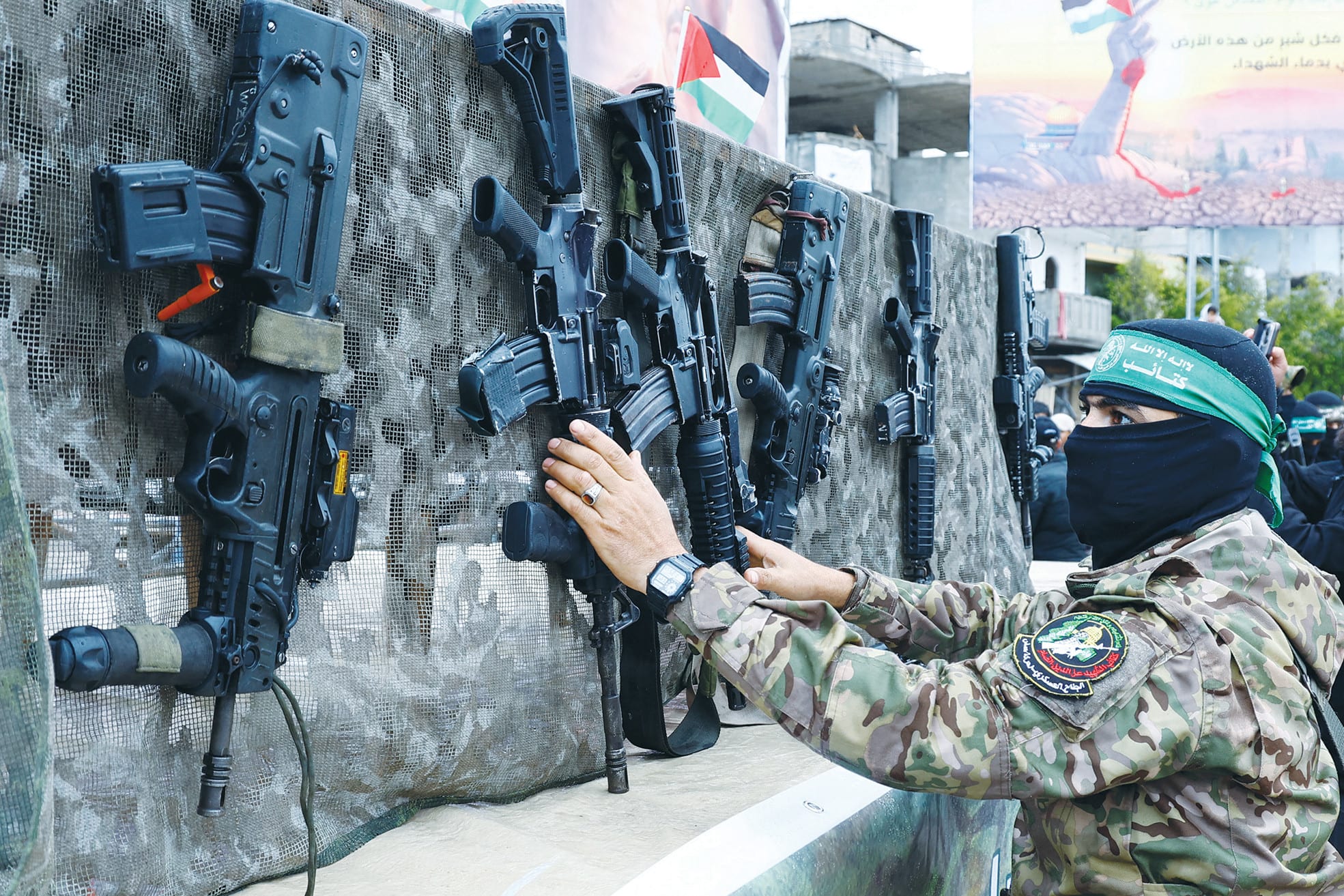 A HAMAS terrorist is seen alongside guns in Gaza. Nobody but the Israeli military can prevent Hamas from rearming or reimposing its reign of terror on Palestinians in Gaza, the writer says. (photo credit: Hatem Khaled/Reuters)