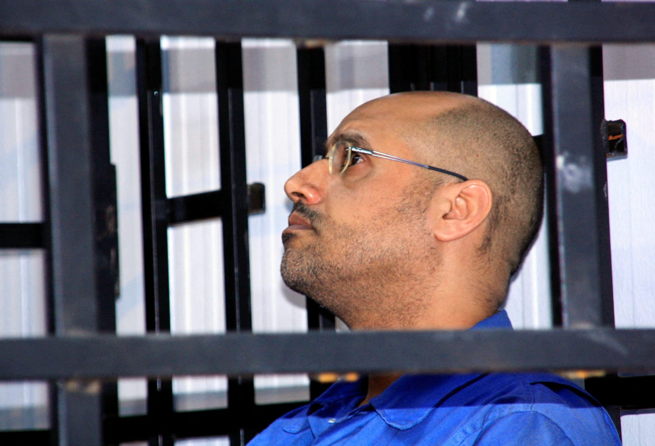 Saif al-Islam Gaddafi, son of late Libyan leader Muammar Gaddafi, attends a hearing behind bars in a courtroom in Zintan May 25, 2014. (photo credit: REUTERS/STRINGER/FILE PHOTO)