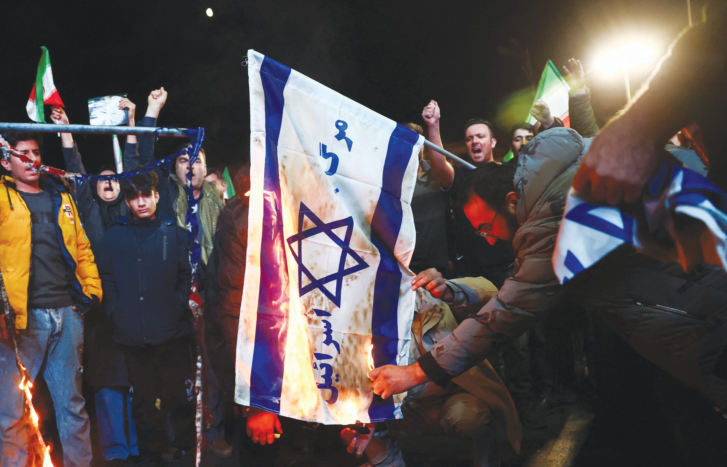 A MAN sets an Israeli flag on fire, as people gather after a two-week ceasefire in the Iran war was announced, in Tehran, earlier this month. Iran’s regime not only harbors genocidal intentions toward Israel but also pursues a broader vision to destabilize the West, the writer says. (photo credit: MAJID ASGARIPOUR/WANA (WEST ASIA NEWS AGENCY) VIA REUTERS)