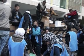UNRWA workers prepare aid parcels at the Palestinian refugee camp of Yarmouk