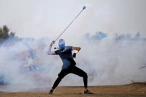 A Palestinian demonstrator uses a sling to hurl back a tear gas canister during an anti-Israel protest at the Israel-Gaza border fence in the southern Gaza Strip October 25, 2019
