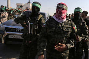 Abu Ubaida, the spokesman of the Izz el-Deen al-Qassam Brigades, walks during an anti-Israel military show by Hamas militants in the southern Gaza Strip