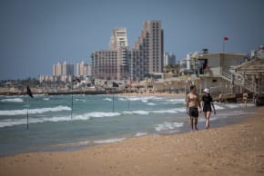 Israelis walk along Dado Beach in Haifa on May 16, 2021.