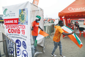  FANS pass through a disinfection cabin in Abidjan as they arrive to watch the Africa Cup of Nations soccer match between Equatorial Guinea and Ivory Coast on a big screen in January. 