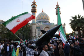  Iraníes portan un modelo de misil durante una celebración tras el ataque del IRGC a Israel, en Teherán, Irán, 15 de abril de 2024.