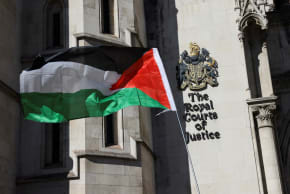 A Palestinian flag is held up outside the Royal Courts of Justice, on the day judges decide whether the co-founder of Palestine Action can challenge the UK government's ban on the group, in London, Britain, September 25, 2025.