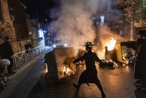 Haredi (ultra-Orthodox) Jewish men block a road and clash with police during a protest against the autopsy of toddlers who died earlier in a daycare, in Jerusalem, January 19, 2026.