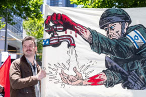 Un manifestante sostiene una pancarta con la imagen de un soldado de las Fuerzas de Defensa de Israel el 11 de enero de 2026 en Melbourne, Australia. La gente se reunió en Melbourne para protestar contra la visita prevista del presidente israelí Isaac Herzog a Australia. 