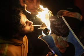 Dos hombres encienden un cigarrillo con una foto en llamas del líder de la República Islámica, Ali Khamenei, mientras la prenden fuego frente a la embajada iraní en Londres, Reino Unido, durante una manifestación celebrada ayer. 