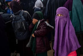 Women and children queue in the rain during a joint security operation by Syria's Kurdish Internal Security Police Force, and the Kurdish-led SDF at Camp Roj where foreign relatives of people suspected of belonging to the Islamic State (IS) group are held, April 5, 2025. 