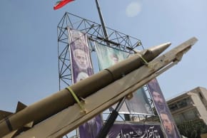 Un sistema de misiles iraní se exhibe junto a una pancarta con una imagen del líder supremo de Irán, el ayatolá Alí Jamenei, durante la Semana de la Defensa Iraní, en una calle de Teherán, Irán