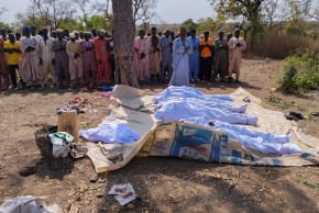 People pray beside the bodies of victims of a terror attack before their burial at Woro community, after an overnight attack by gunmen that killed dozens of residents, in Kaiama Local Government Area of Kwara State, Nigeria, February 4, 2026.
