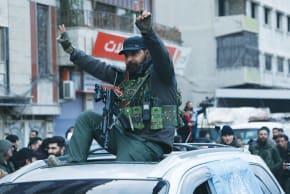 A MEMBER of the Kurdish Internal Security Forces rides on a car, while vehicles of the internal security forces of the Syrian government arrive in the city of Qamishli during the curfew, following an agreement between the Syrian Democratic Forces and the Syrian government on Tuesday.