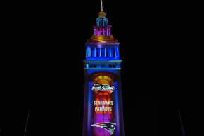 The Seattle Seahawks and the New England Patriots logos projected on the Ferry Building. 