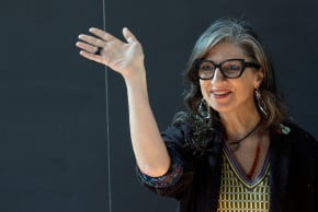 United Nations Special Rapporteur Francesca Albanese waves ahead of a conference.
