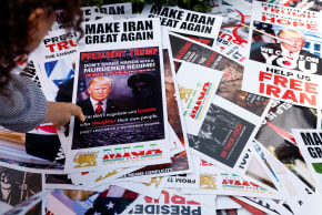 A person picks up a poster from a pile while taking part in a rally in support of Iranian protesters during a global day of action in Los Angeles, California, US, February 14, 2026