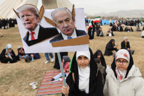A girl holds up a placard with images of US President Donald Trump and Israeli Prime Minister Benjamin Netanyahu. during the 47th anniversary of the Islamic Revolution in Tehran, Iran February 11, 2026.