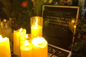 A photograph taken on January 18, 2025 shows lit candles and a placard displayed during a vigil in the centre of Brighton, England, for people held hostage by Hamas in Gaza.
